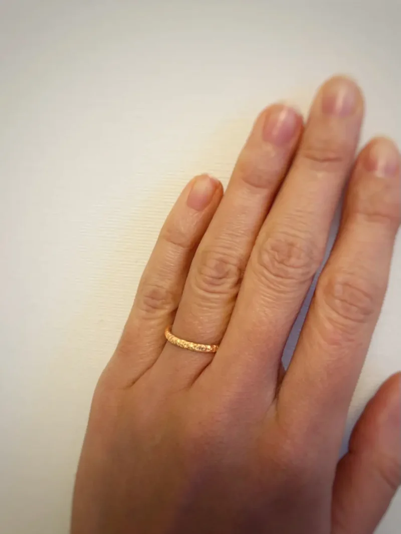 schmaler Ring an Ringfinger aus Gold Frauen Hand
