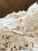 Kugelring Gelbgold auf weißem Stoff