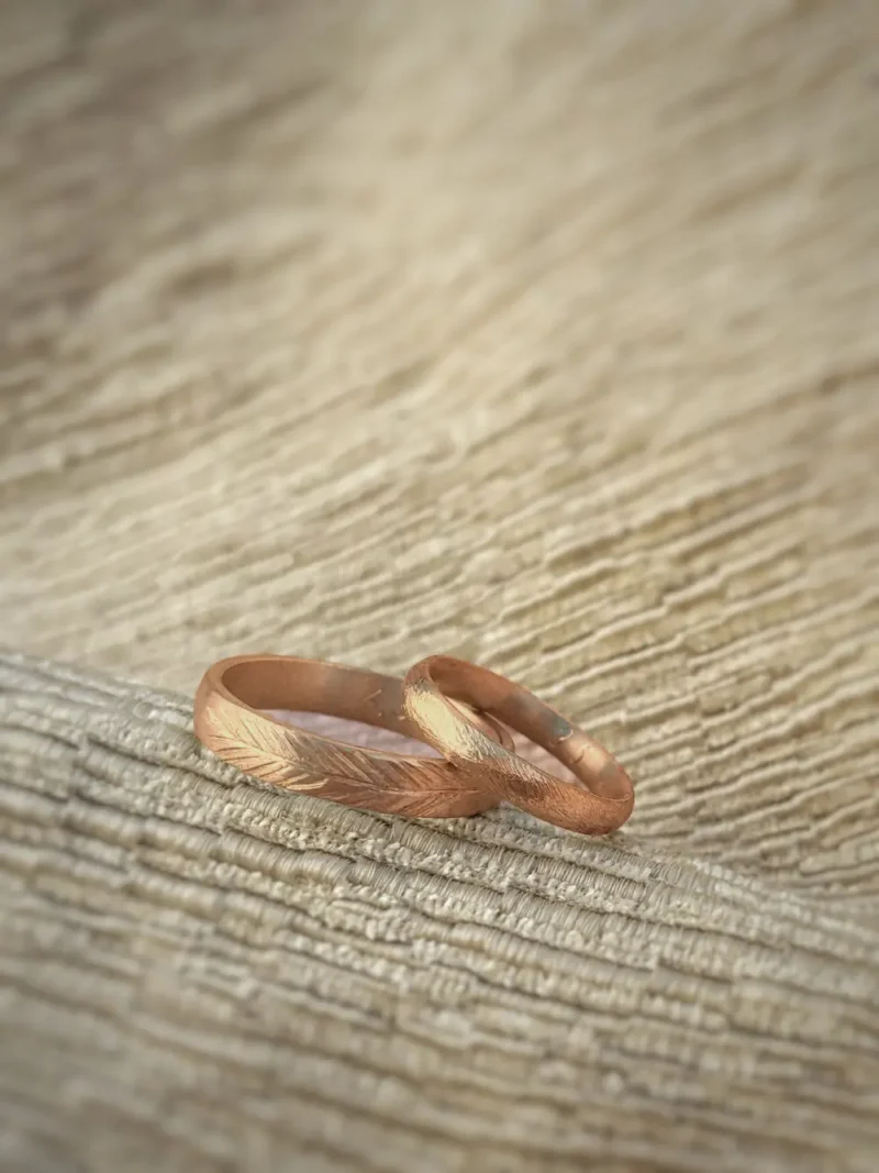 Rotgoldenes Ehering Paar mit Muster und grober Struktur