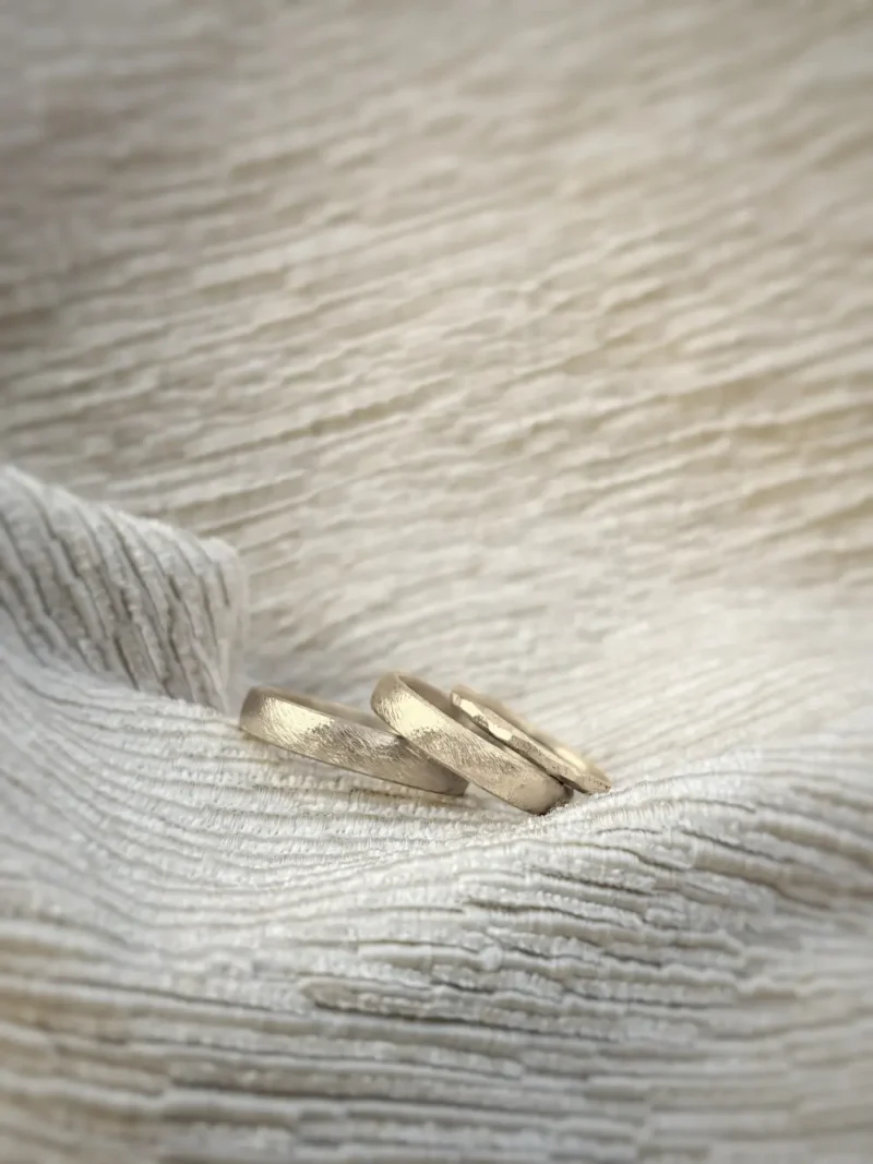 Cremefarbene Eheringe mit gefeilter Oberfläche - dazu Vorsteckring Heidi