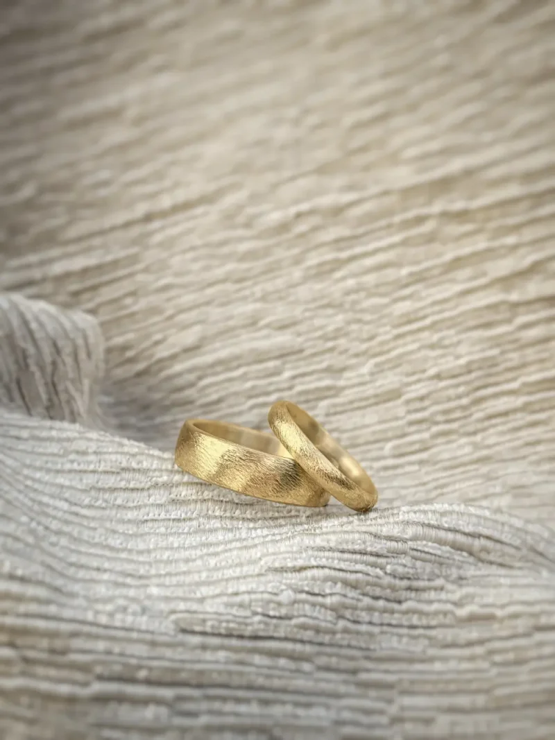 Eheringe mit grob gefeilter Sonnenstrahlen Optik - helles Gelbgold