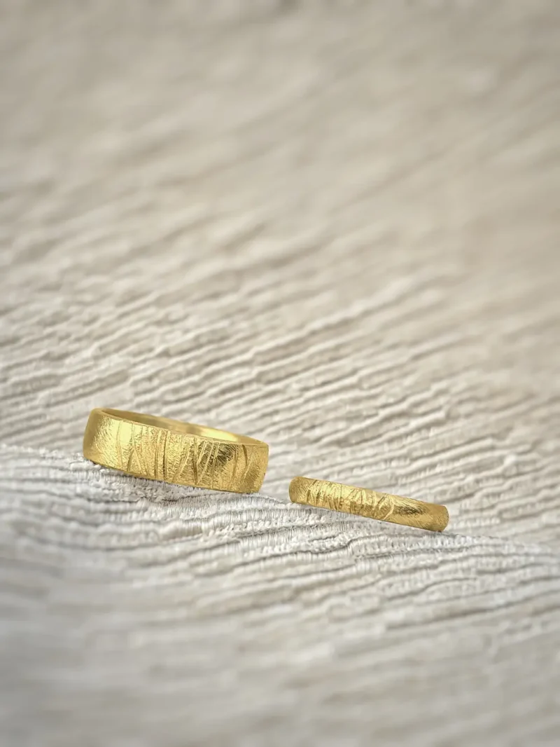 Breiter und schmaler Ehering aus hellgelbem Gold mit Muster