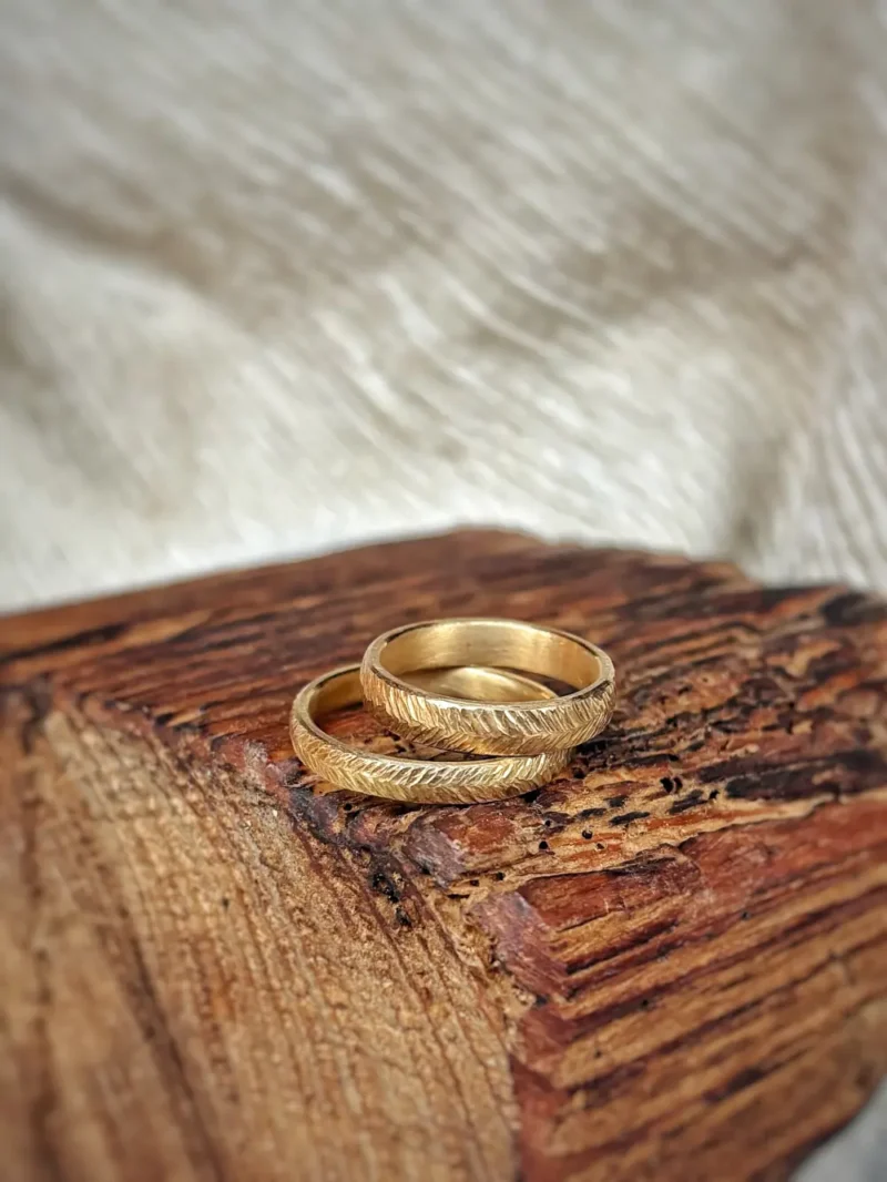 Eheringe mit geschmiedeter, federartiger Oberfläche aus Gelbgold