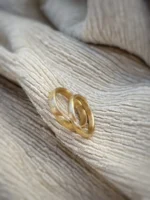 kleine Wellen - Eheringe mit fein gefeilter Struktur aus 750 Gelbgold auf Stoff liegend