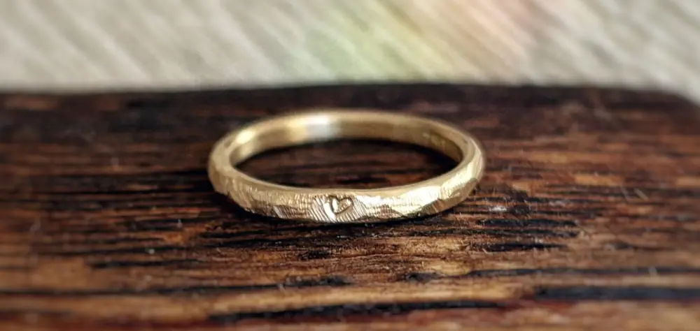 Herz Heidi Ring aus Gelbgold auf Holz liegend