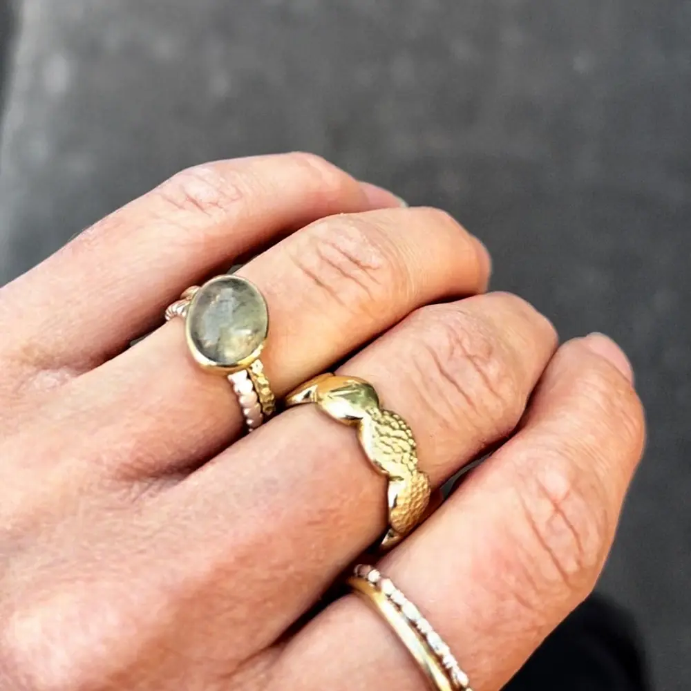 verschiedene Unikat Gelbgold und Silber Ringe an der Hand fotografiert
