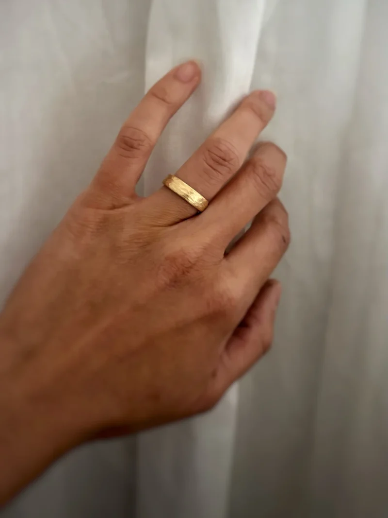 Gelbgoldener Eisberg Ehering an Frauenhand getragen